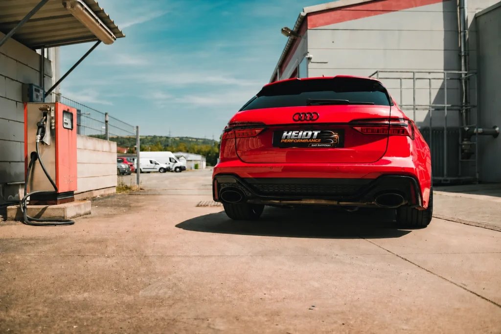 Roter Audi mit passgenauem HEIDT-Performance-Kennzeichen im Hof